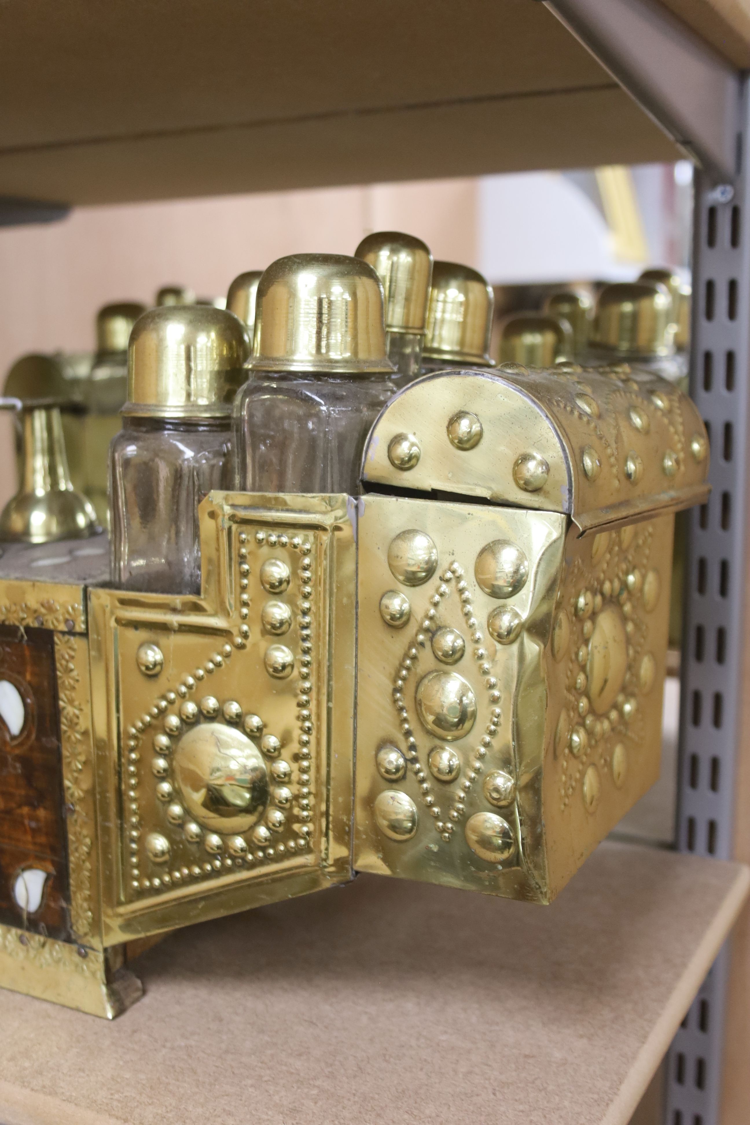 An Indian brass & hardwood shoe shiner's set, with twelve flasks. 57cm. long. 15cm. deep. 28cm. high